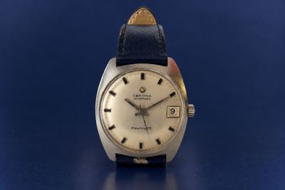 a close up of a wrist watch on a blue surface