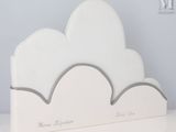a white cloud shaped bookend on a white table