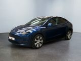 La Tesla Model Y bleue est garée dans une pièce blanche