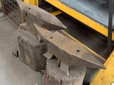 a large piece of metal sitting next to a pile of wood