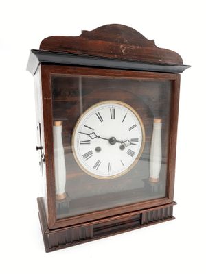 une petite horloge en bois avec des chiffres romains sur le cadran