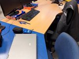 a blue desk with a laptop and a monitor on it