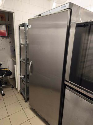 stainless steel refrigerators in a commercial kitchen with tiled flooring