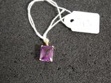 a close up of a necklace with a purple stone on it