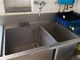two sinks in the kitchen with blue bins on the counter