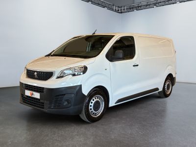 La camionnette blanche est garée dans une grande pièce d'un immeuble.