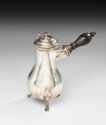 une cafetière en argent posée sur un support et munie d'une poignée en bois