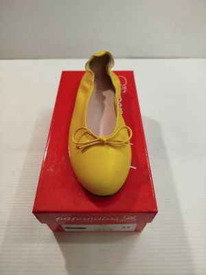 des ballerines dans une boîte posée sur une surface blanche, avec une boîte rouge à côté