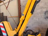 une grue jaune posée sur un immeuble
