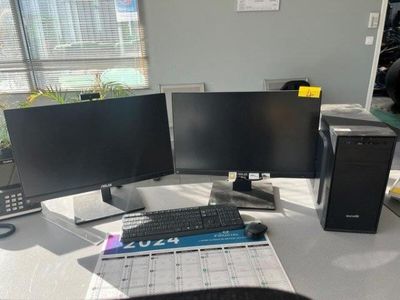 a computer desk with two monitors and a keyboard