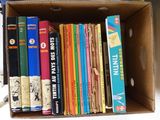 many books in a cardboard box on a table