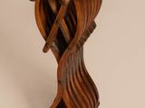 an image of a wooden sculpture of a bird on a stand