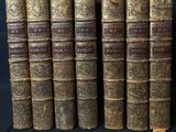 six vieux livres sont alignés sur un fond noir