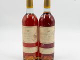 deux bouteilles de vin posées l'une à côté de l'autre sur une surface blanche