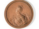 portrait of a woman in a dress and hat in a bronze medallion