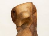 sculpture of a wooden head on a white pedestal against a white background