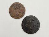 two old coins with a crown on them sitting on top of a table