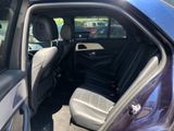 a blue car with the door open in a parking lot