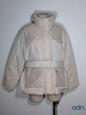 jacket on a mannequin stand with a white wall in the background