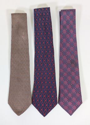 three ties are lined up in a row on a white surface