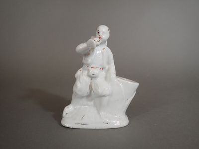 a figurine of a man sitting on top of a rock