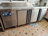 a stainless steel counter in a kitchen with a tiled floor