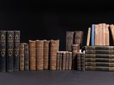 several old books are stacked on top of each other on a table