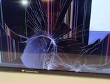 a tv screen with a broken screen sitting on a table