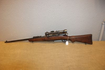 le fusil est posé sur la table près du mur