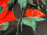 bedspread with red roses and green leaves on a black background