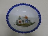 a blue and white bowl with a picture of a man and a woman in a boat
