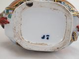 a close up of a vase on a white surface