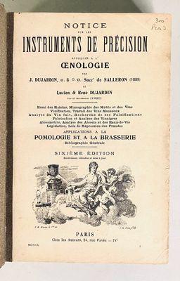 un vieux livre posé sur une table à côté d'un mur blanc