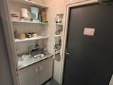 a black door in a small kitchen with a black trash can
