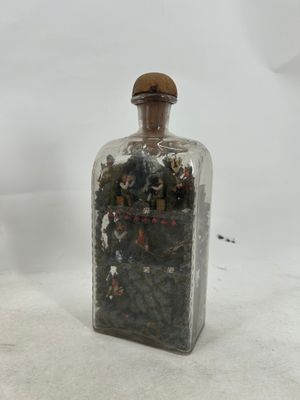 a glass bottle with a small amount of rocks inside of it