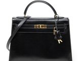 a black leather handbag with a gold lock on the handle