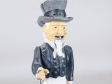 a figurine of a man with a hat and a cane