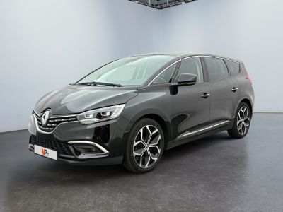 a grey car is parked in a room with a black floor