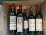 six bouteilles de vin rouge dans un carton sur une table