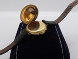 a small black bag with a gold watch inside of it
