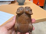 une personne tenant une petite statue de tortue