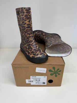 une paire de bottes à imprimé léopard posée sur une boîte en carton