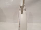 a white bottle with a toothbrush in it sitting on a sink