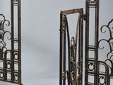 three metal gates with decorative designs on them against a white background