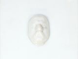 une photo d'un visage dessiné avec du dentifrice sur une surface blanche