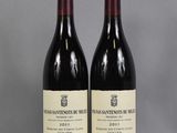 two bottles of wine sitting on top of a table next to each other