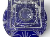 a blue glass bowl with a flower design on it