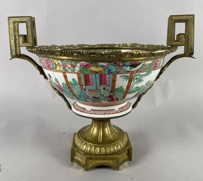 un vase richement décoré, posé sur un socle doré, sur fond blanc