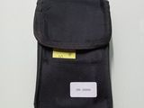 une petite pochette noire avec une étiquette jaune dessus