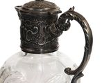 a glass pitcher with a metal handle on a white background